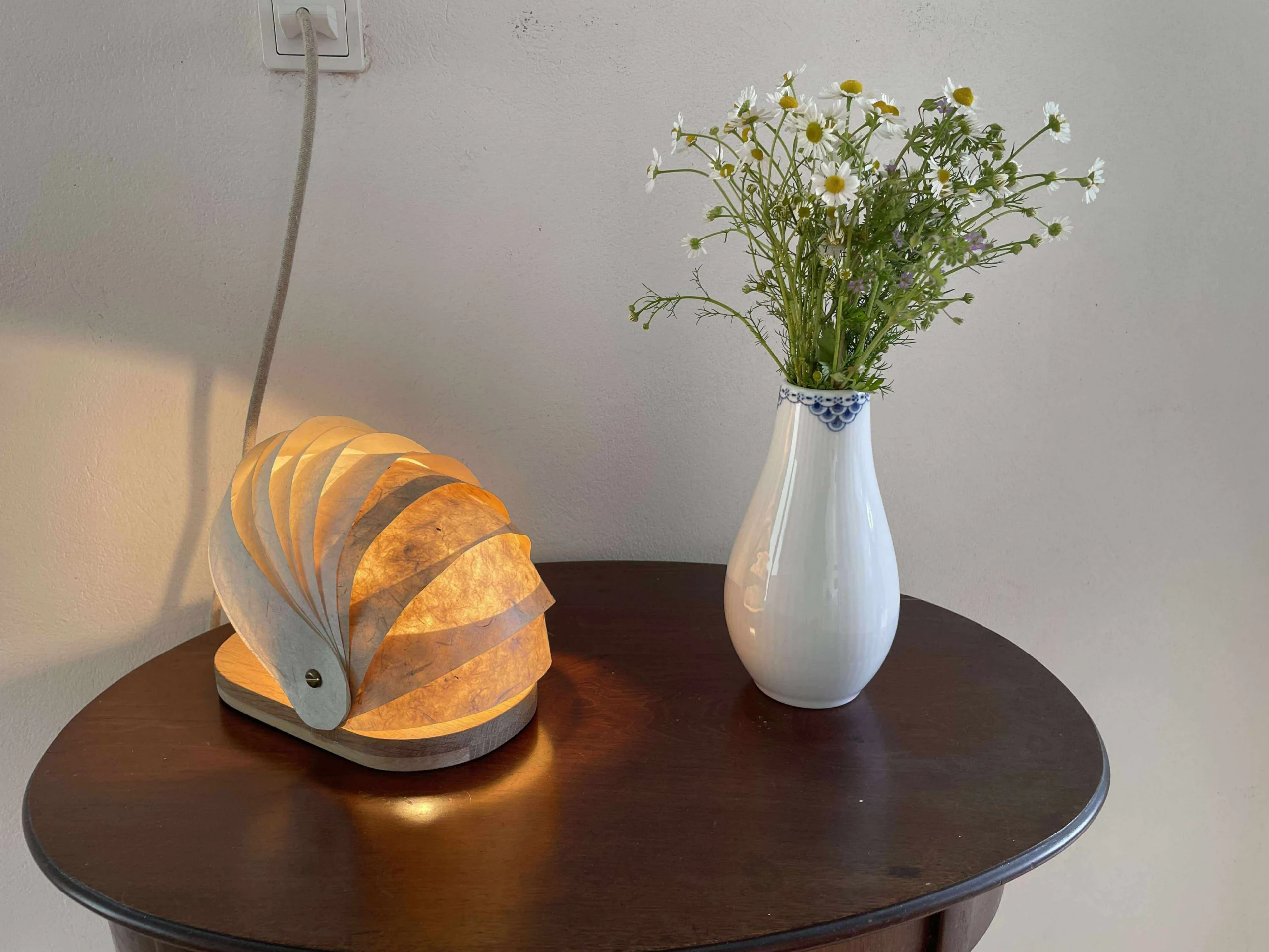 Interaktiv lampe, hvor lyset formes ved at skubbe papirstrimler.